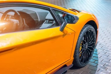 Ön kanat ve direksiyona gece şehirde bir park yerinde bir supercar altındadır.