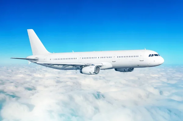 Avião de passageiros voar em uma altura acima nuvens nubladas e céu azul . — Fotografia de Stock