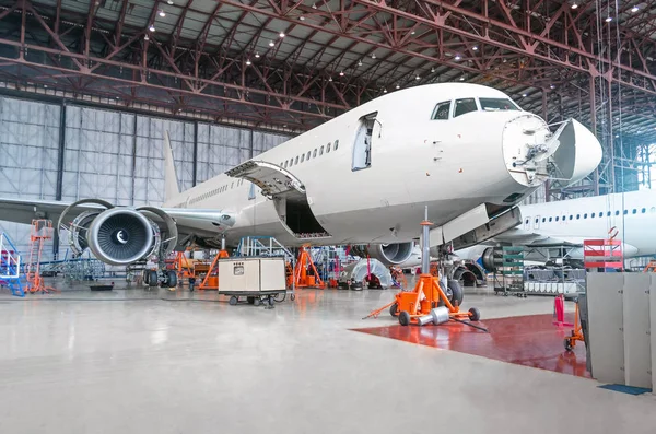 Avión de pasajeros en mantenimiento de reparación de motores y fuselajes —  Fotos de Stock