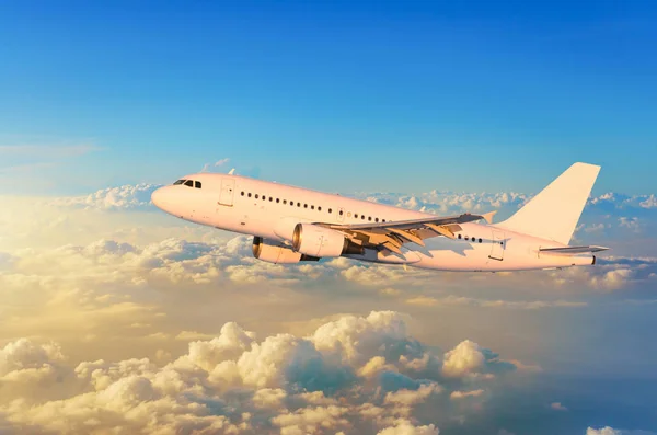 Flying airplane above the clouds horizon sky with bright sunset colors. — Stock Photo, Image