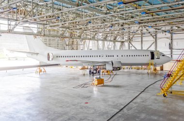 Yolcu uçak motoru, Havaalanı hangar onay tamir bakım. Uçak yan görünüm, açık hangar kapıları.