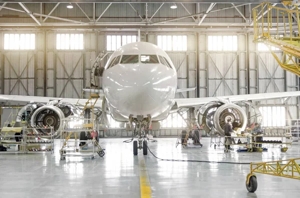 Samoloty pasażerskie na utrzymanie zdemontowany silnik silnik ostrzy i naprawa kadłuba w hangarze lotniczym. — Zdjęcie stockowe