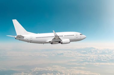 Yolcu uçak fly bir yüksekliği yukarıda overcast bulutlar ve mavi gökyüzü üzerinde.