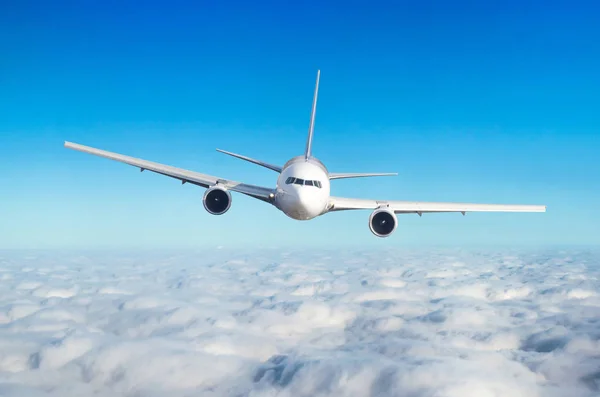 Passenger airplane flying at flight level high in the sky above the clouds. View directly in front, exactly. — Stock Photo, Image
