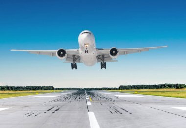 Mavi gökyüzü ile iyi açık havada bir piste iniş yolcu uçak.
