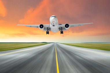 Hız hareket parlak kırmızı günbatımı sırasında akşamları bir piste iniş Ayrilis uçan uçak.