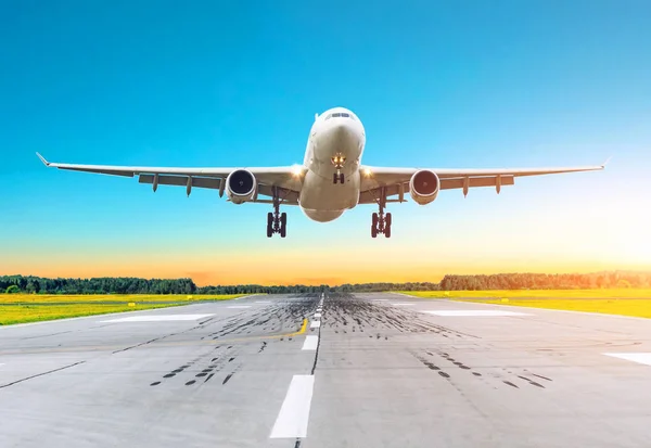 Airplane flying arrives landing on a runway in the evening. — Stock Photo, Image