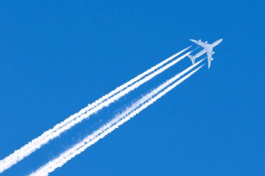 Uçak dört büyük motorları Havacılık Havaalanı contrail bulutlar.