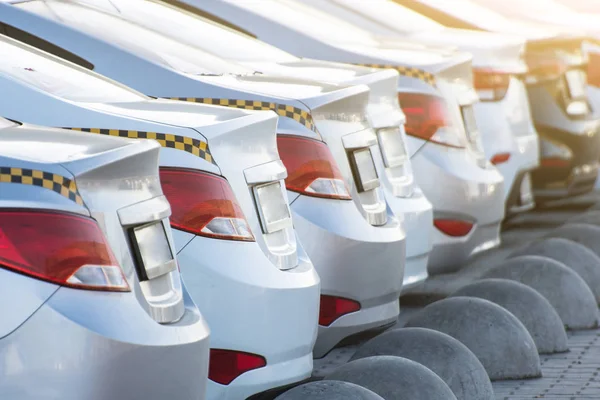 Aantal taxi wagens, een uitzicht op de achterbumper en koplampen met een stam. — Stockfoto