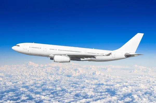 Avion de passagers volent sur une hauteur au-dessus des nuages nuageux et ciel bleu . — Photo