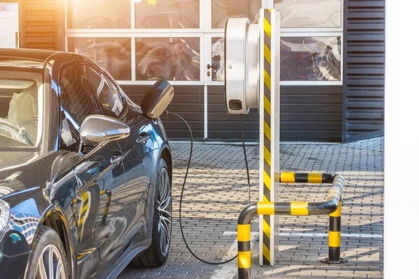 Tanken voor elektrische auto's e-mobiliteit. Opladen van de machine, het klepje is open, de stekker onder spanning herstelt lading van de batterij. — Stockfoto