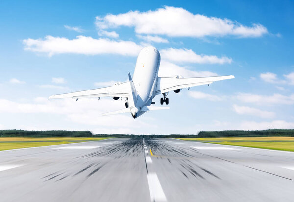 Самолет летит вылет на взлетно-посадочной полосе аэропорта хорошая погода с голубым небом облаков на взлетно-посадочной полосе. Вид сзади
.