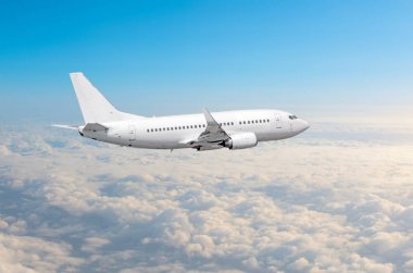 Beyaz uçak yükseklik, uçuş seviyesi yüksek bulutlar mavi gökyüzü yukarıda gökyüzünde uçar.