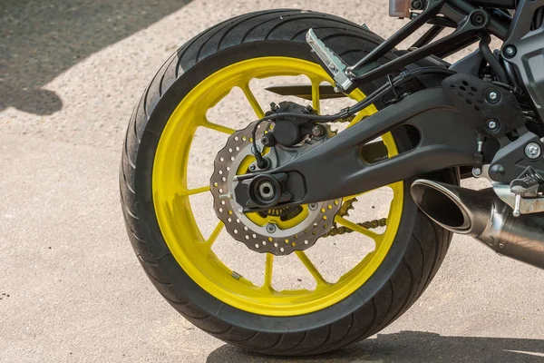 Rueda de una motocicleta con un disco amarillo estacionado en la ciudad, primer plano . —  Fotos de Stock