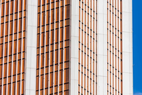Cristal de ángulo rojo, borgoña, fachadas marrones de una ventana de rascacielos financieros, una esquina de un edificio de primer plano . — Foto de Stock