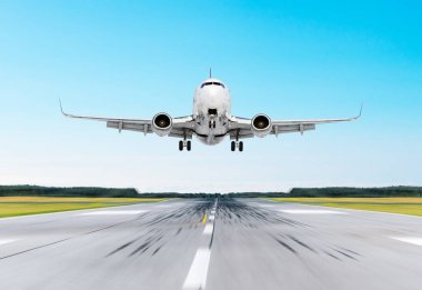 Açık gökyüzü parlak günde bir piste iniş varış uçan uçak.