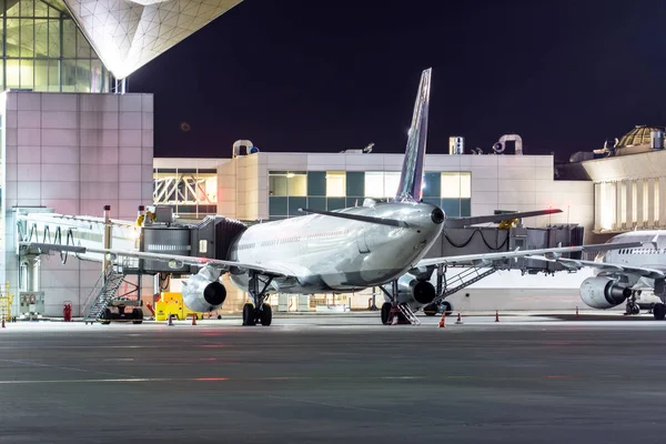 Avión de pasajeros en el aeropuente del telescopio en el aeropuerto ni — Foto de Stock