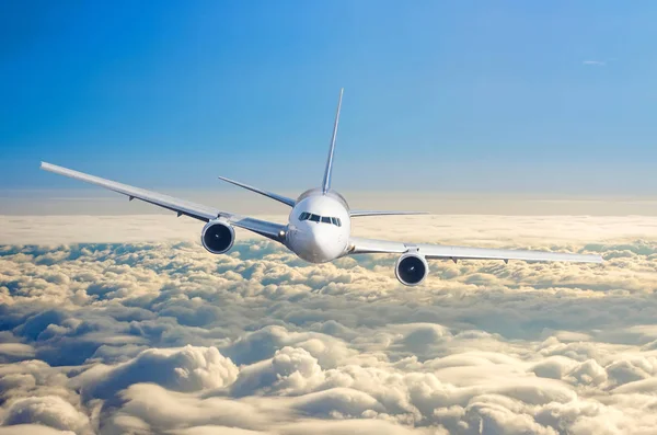 雲と青空日の出の上空の飛行レベル高で飛んでいる旅客機. — ストック写真