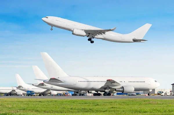 旅客航空機行、駐機空港、他の平面のプッシュ バックけん引の出発前に、サービスに。1 つの 2 階建て飛行機が青空に滑走路から離陸します。. — ストック写真