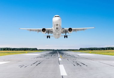 Mavi gökyüzü ile iyi açık havada bir piste iniş yolcu uçak.
