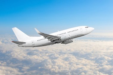 Yolcu uçak fly bir yüksekliği yukarıda overcast bulutlar ve mavi gökyüzü üzerinde.