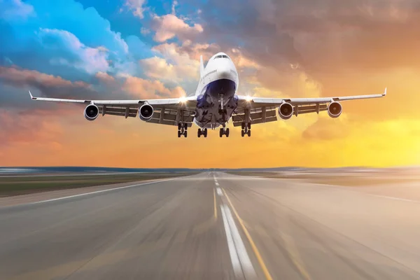 Vliegtuig met vier motoren vliegen aankomst landing op een landingsbaan in de avond tijdens een heldere rode zonsondergang. — Stockfoto