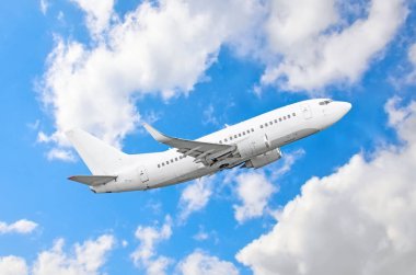 Yolcu uçak fly bir yüksekliği yukarıda overcast bulutlar ve mavi gökyüzü üzerinde.