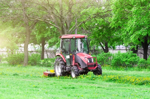 赤いトラクター、芝刈り機、鋏芝生公園で路地で. — ストック写真