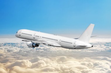 Yolcu uçak fly bir yüksekliği yukarıda overcast bulutlar ve mavi gökyüzü üzerinde.