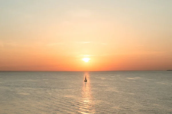 Segelboot auf dem Meer bei Sonnenuntergang in scharlachroter Farbe. — Stockfoto