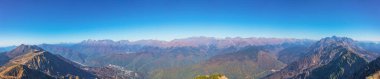 Dağ vadisinin geniş panoramik manzarası ve açık bir gökyüzü olan dağ zirveleri..