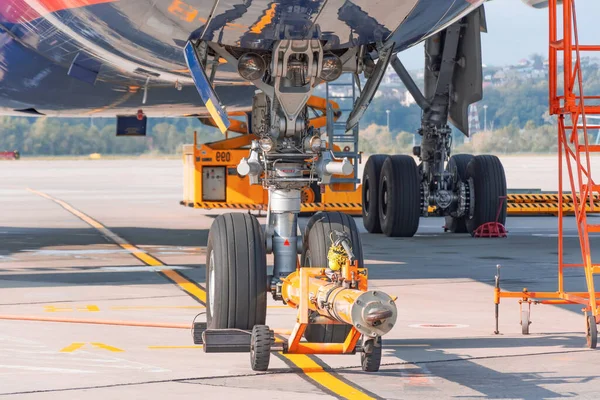 TUG carrier for huge airplane, trailer front landing gear pushback aerodrome tractor with airplane on the runway in airport. — Stock Photo, Image