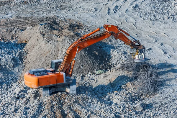 Graafmachine met magneet aan de giek voor het laden van metaalafval. — Stockfoto