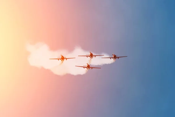 Négy könnyűmotoros repülőgép repül messziről, füstös nyomot hagyva.. — Stock Fotó