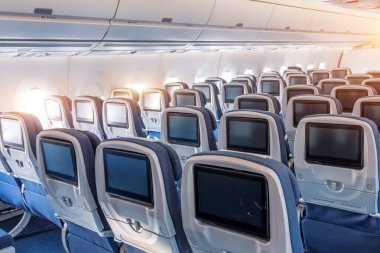 Ekonomi sınıfı boş koltuklar ve eğlence sistemi geniş gövdeli bir uçakta..