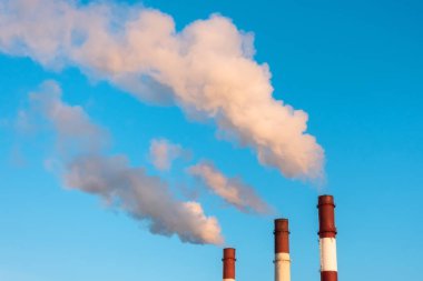 Kirlilik endüstrisinin boruları akşam mavi gökyüzünde atmosfere kirletici hava saçıyor..