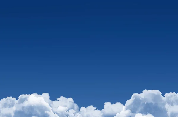 Klasik mavi gökyüzü ve aşağıdaki tüylü kümülüs bulutları, arka plan. — Stok fotoğraf