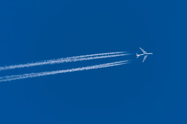 Trail from the plane with four enigine the blue sky. — Stock Photo, Image