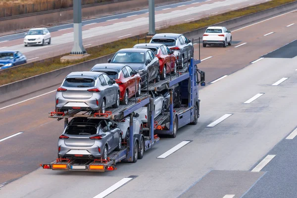 Vervoer van nieuwe auto 's op een aanhangwagen met een vrachtwagen voor levering aan dealers. — Stockfoto