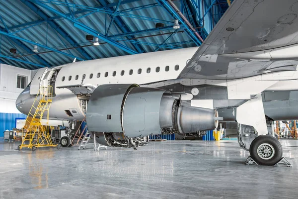 Narrow-body passenger aircraft for maintenance in the hangar, side view of the engine and landing gear. — Stock Photo, Image