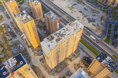 İnşaat vinçleri manzaralı büyük ölçekli bir konut kompleksinin havadan görünüşü.