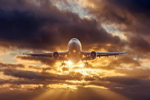 Jet letadla létající nad dramatickým západem slunce tmavé mraky oblohy, nejrychlejší způsob moderní dopravy. — Stock fotografie