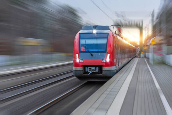Railway station with head locomotive high speed commuter train with motion blur effect