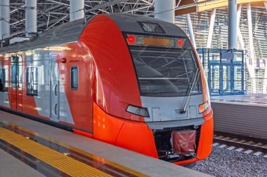 Yolcu elektrikli tren istasyon peronundan ayrılır ve demiryolu hattına biner..