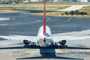 Piste giderken bir yolcu uçağının arka görüntüsü.