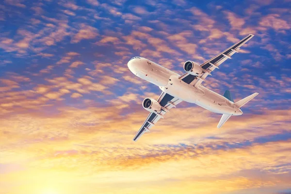 夕方の雲を背景に旅客機を飛ばす太陽に照らされた 旅行の概念 — ストック写真