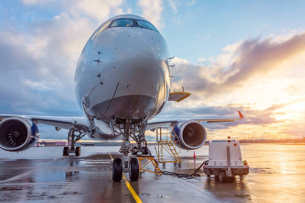 Airplane before flight, aircraft maintenance at the airport. Sunset at the aerodrome