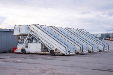Havaalanına park etmiş bir uçaktan yolcu indirmek ve yolcu indirmek için bir sıra iskele.