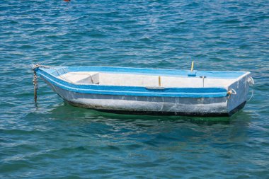 Limanda ıssız bir tekne. Suyun içinde demirlemiş.