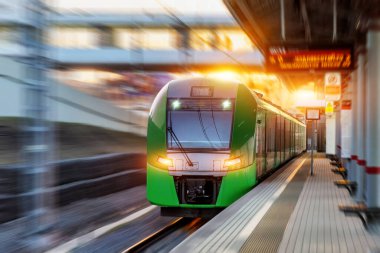 Yolcu elektrikli tren şehir manzarasındaki istasyona akşam trafiğinin yoğun olduğu saatte varır.